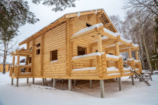 General view of a wooden house under construction winter General view of a wooden house under construction winter